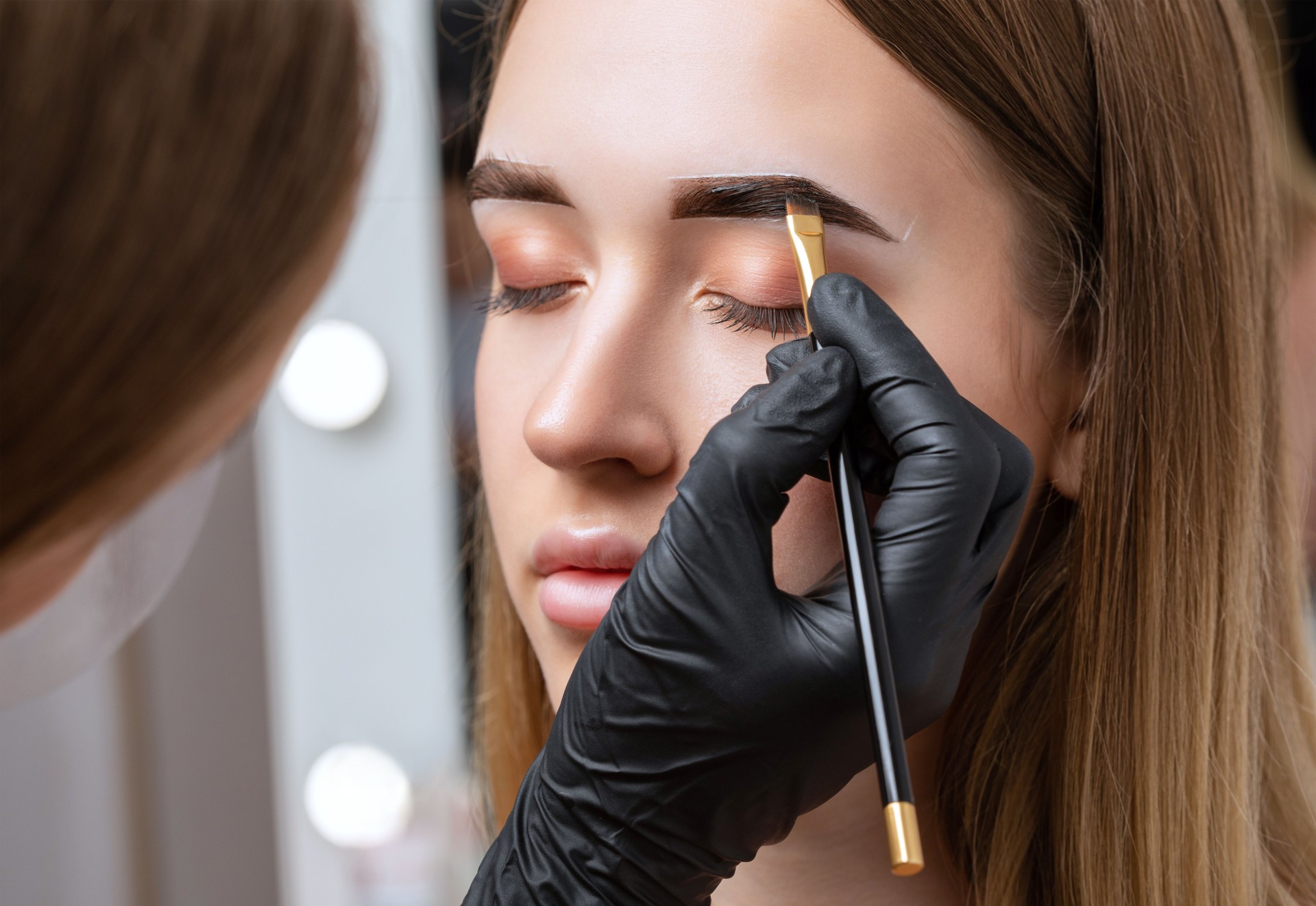 The make-up artist does Long-lasting styling of the eyebrows of the eyebrows and will color the eyebrows. Eyebrow lamination. Professional make-up and face care.